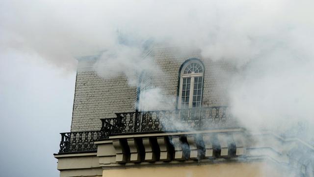 Weißer Rauch steigt von der Spitze des Zwehrenturms auf. Der Rauch vernebelt das Gebäude fast vollständig.