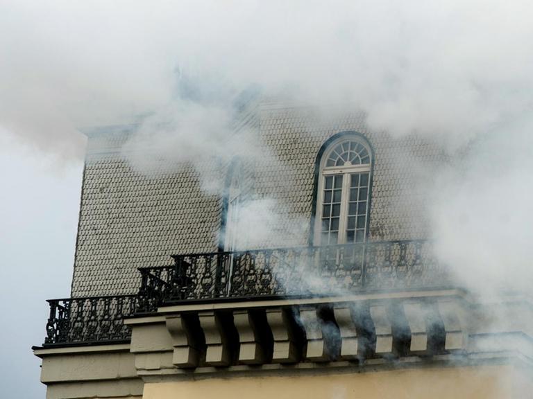 Weißer Rauch steigt von der Spitze des Zwehrenturms auf. Der Rauch vernebelt das Gebäude fast vollständig.