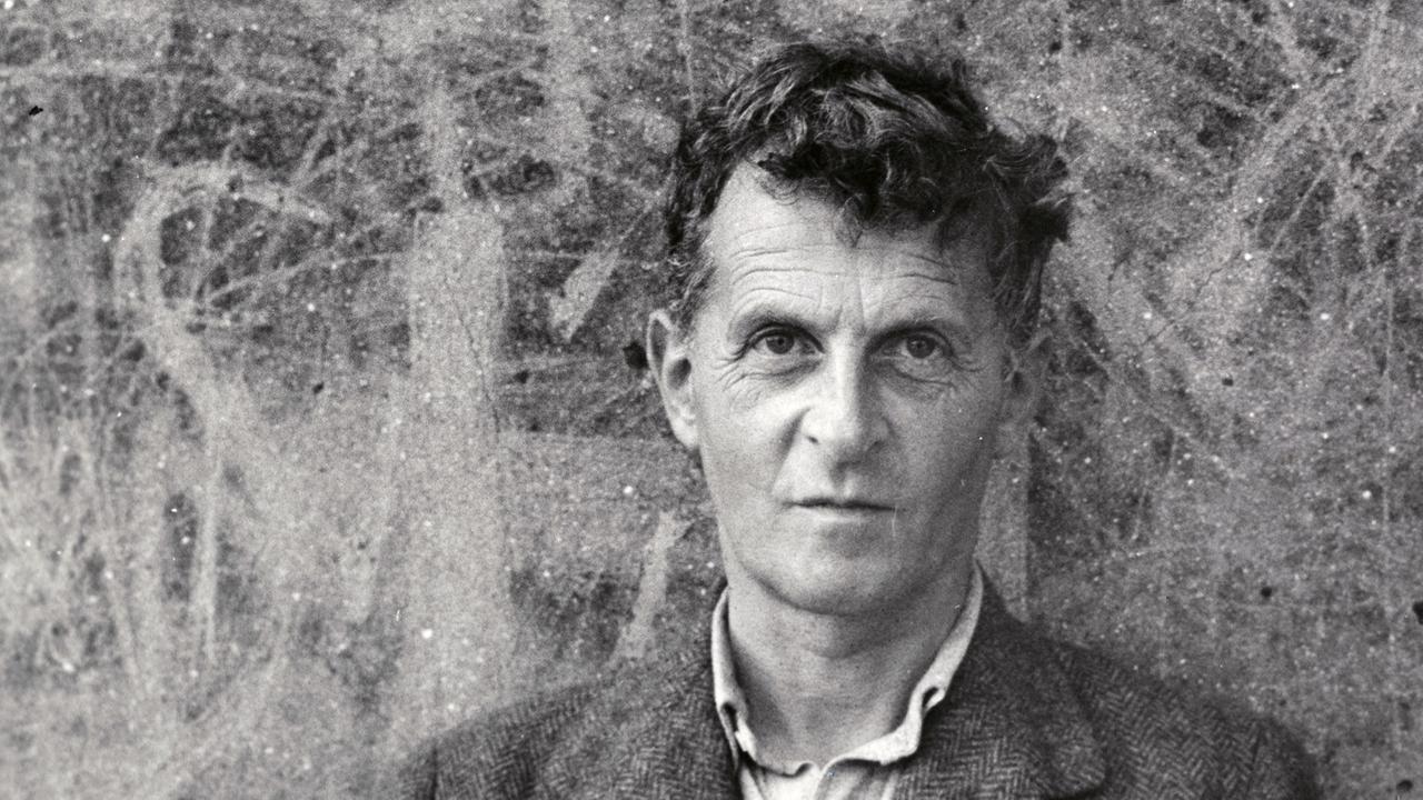 Schwarz-Weiß-Aufnahme von Ludwig Wittgenstein, vor einer zerkratzten Wand stehen. Schwarz-Weiß-Aufnahme von Ludwig Wittgenstein, vor einer zerkratzten Wand stehen.