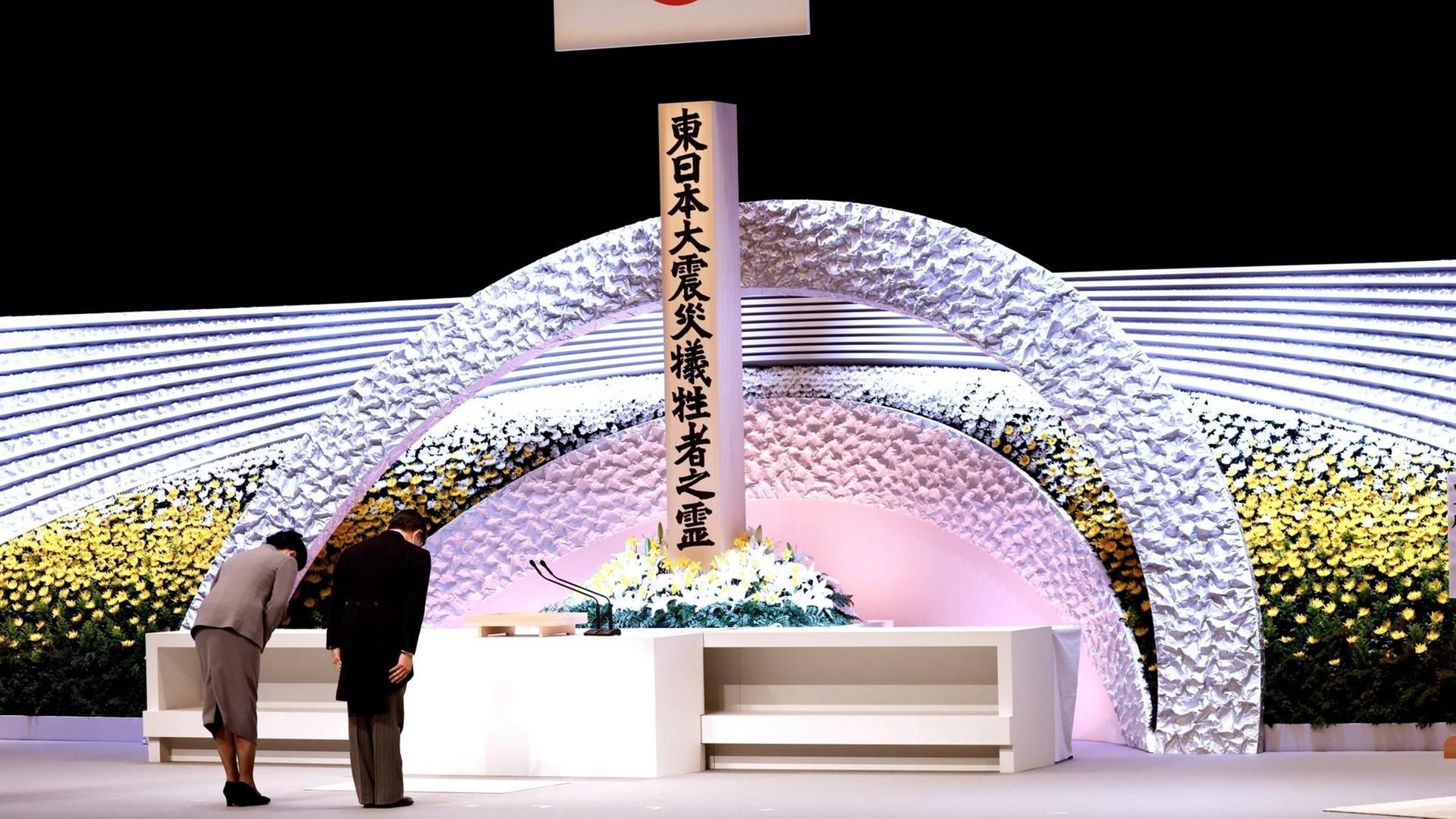 Der Kaiser von Japan und seine Frau verbeugen sich vor einem Altar.