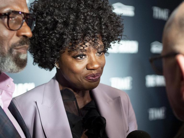 Viola Davis trägt einen fliederfarbenen Blazer und gibt ein Interview.
