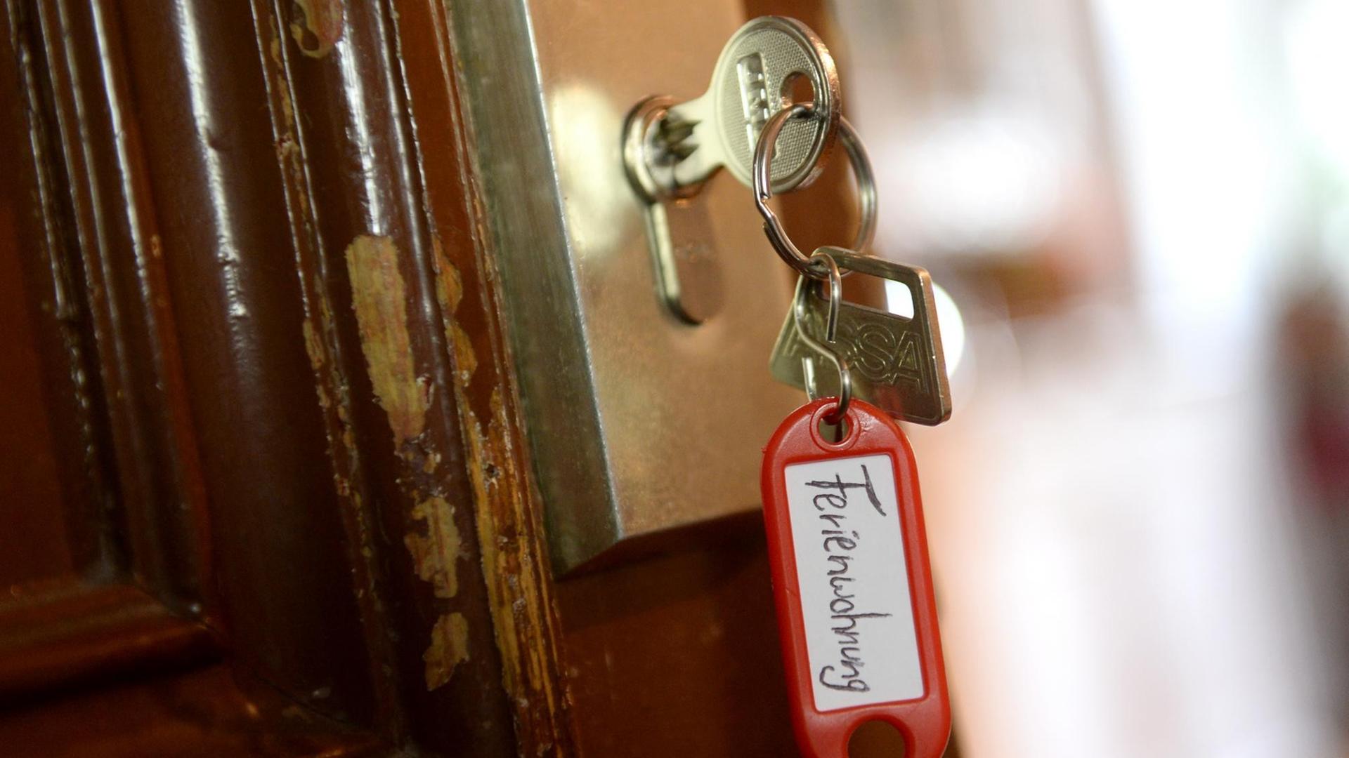 Ein Schlüssel mit einem Schlüsselanhänger, auf dem "Ferienwohnung" zu lesen ist, hängt an einer Wohnungstür in Berlin.