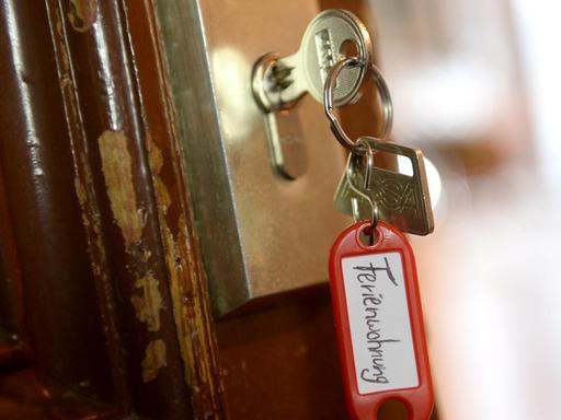Ein Schlüssel mit einem Schlüsselanhänger, auf dem "Ferienwohnung" zu lesen ist, hängt an einer Wohnungstür in Berlin.