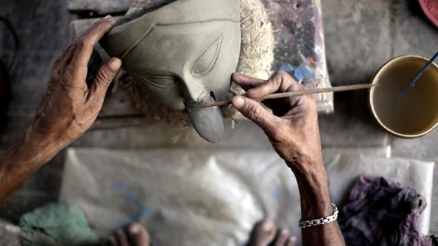 Ein indischer Tonkünstler arbeitet an einer Figur der Göttin Kali.