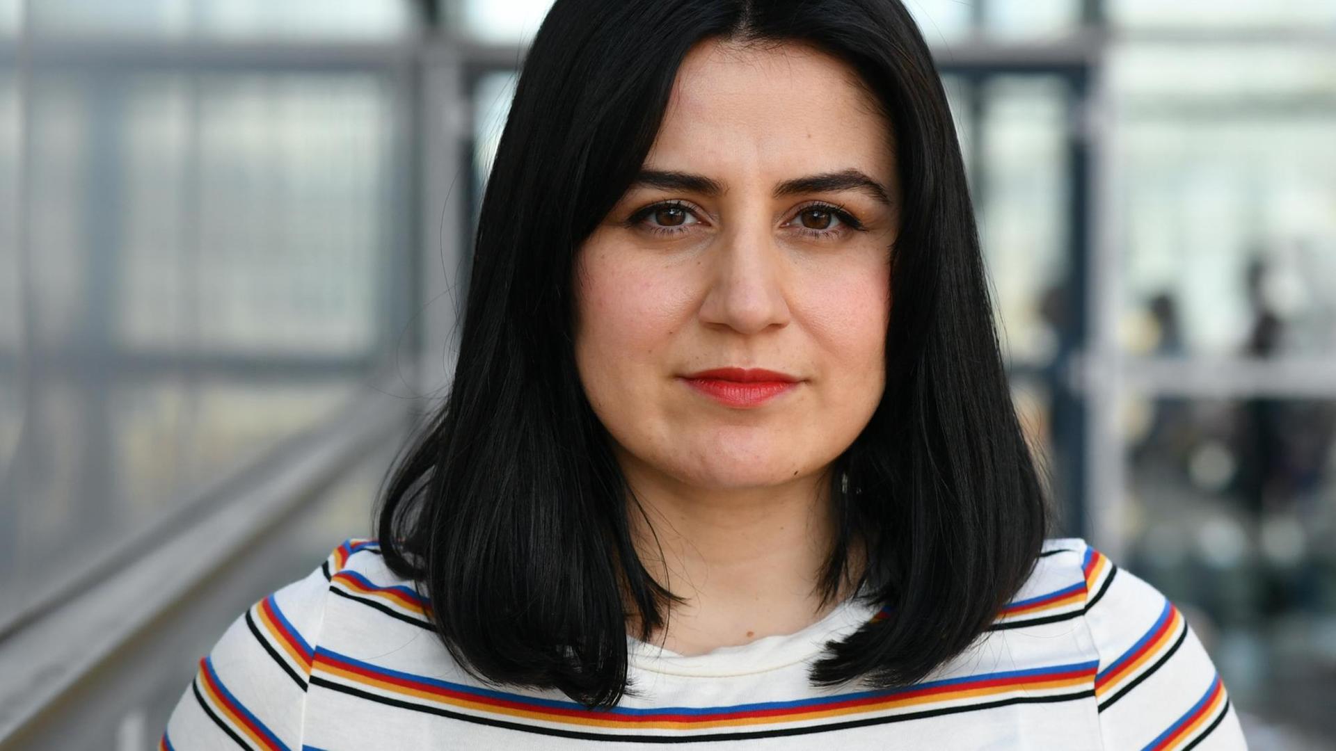 Autorin Karosh Taha steht auf einem Gang auf dem Leipziger Messegelände, der Hintergrund ist unscharf. Autorin Karosh Taha steht auf einem Gang auf dem Leipziger Messegelände, der Hintergrund ist unscharf.