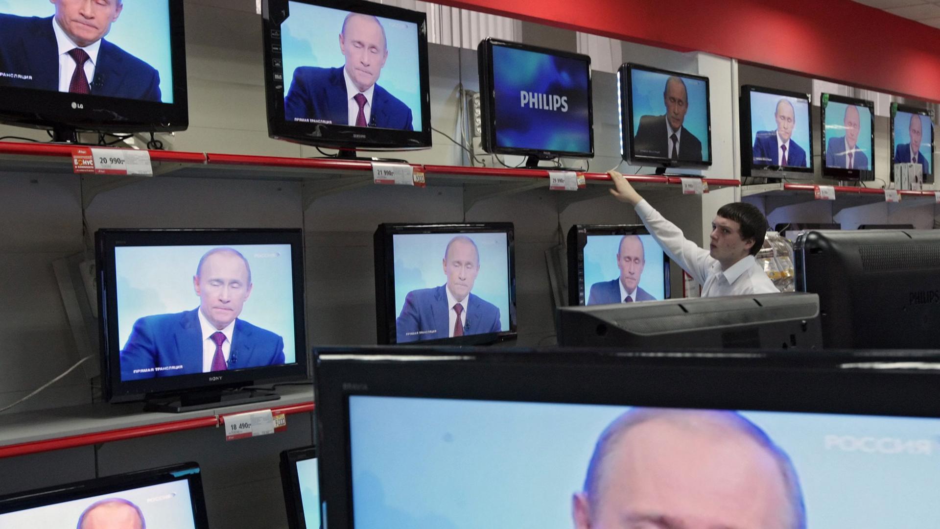 Wladimir Putin ist in einem Geschäft auf diversen TV-Bildschirmen zu sehen. Wladimir Putin ist in einem Geschäft auf diversen TV-Bildschirmen zu sehen.