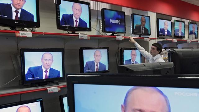 Wladimir Putin ist in einem Geschäft auf diversen TV-Bildschirmen zu sehen.