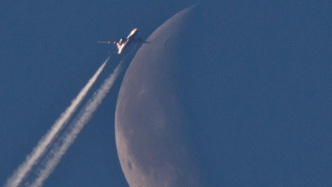 Ein Flugzeug fliegt über Nürnberg (Bayern) scheinbar am Mond vorbei. Ein Flugzeug fliegt über Nürnberg (Bayern) scheinbar am Mond vorbei.