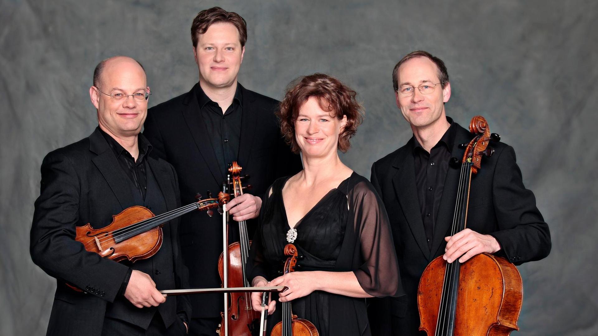 Die vier Musiker des Mandelring Quartetts halten ihre Instrumente in der Hand Die vier Musiker des Mandelring Quartetts halten ihre Instrumente in der Hand