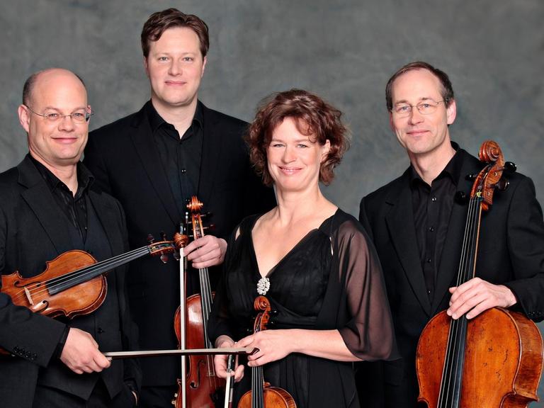 Die vier Musiker des Mandelring Quartetts halten ihre Instrumente in der Hand