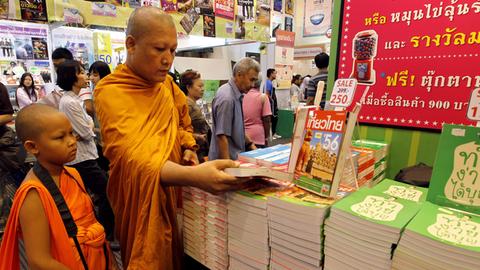 Ein Mönch und sein Schüler auf einer Buchmesse in Bangkok