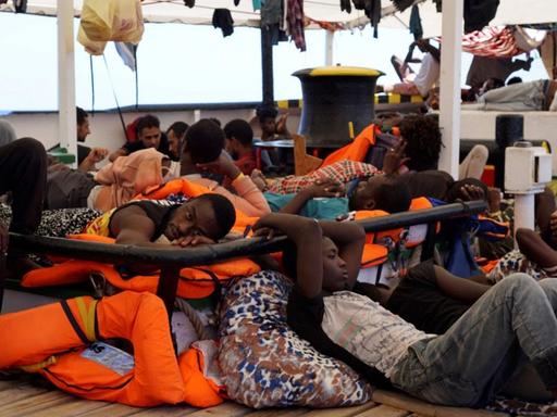 Das Bild zeigt Flüchtlinge an Bord des Rettungsschiffs "Open Arms", die auf Deck ausharren.