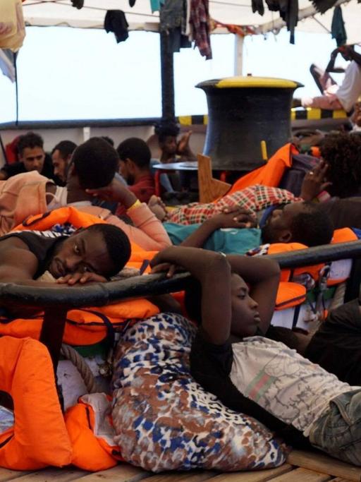 Das Bild zeigt Flüchtlinge an Bord des Rettungsschiffs "Open Arms", die auf Deck ausharren.