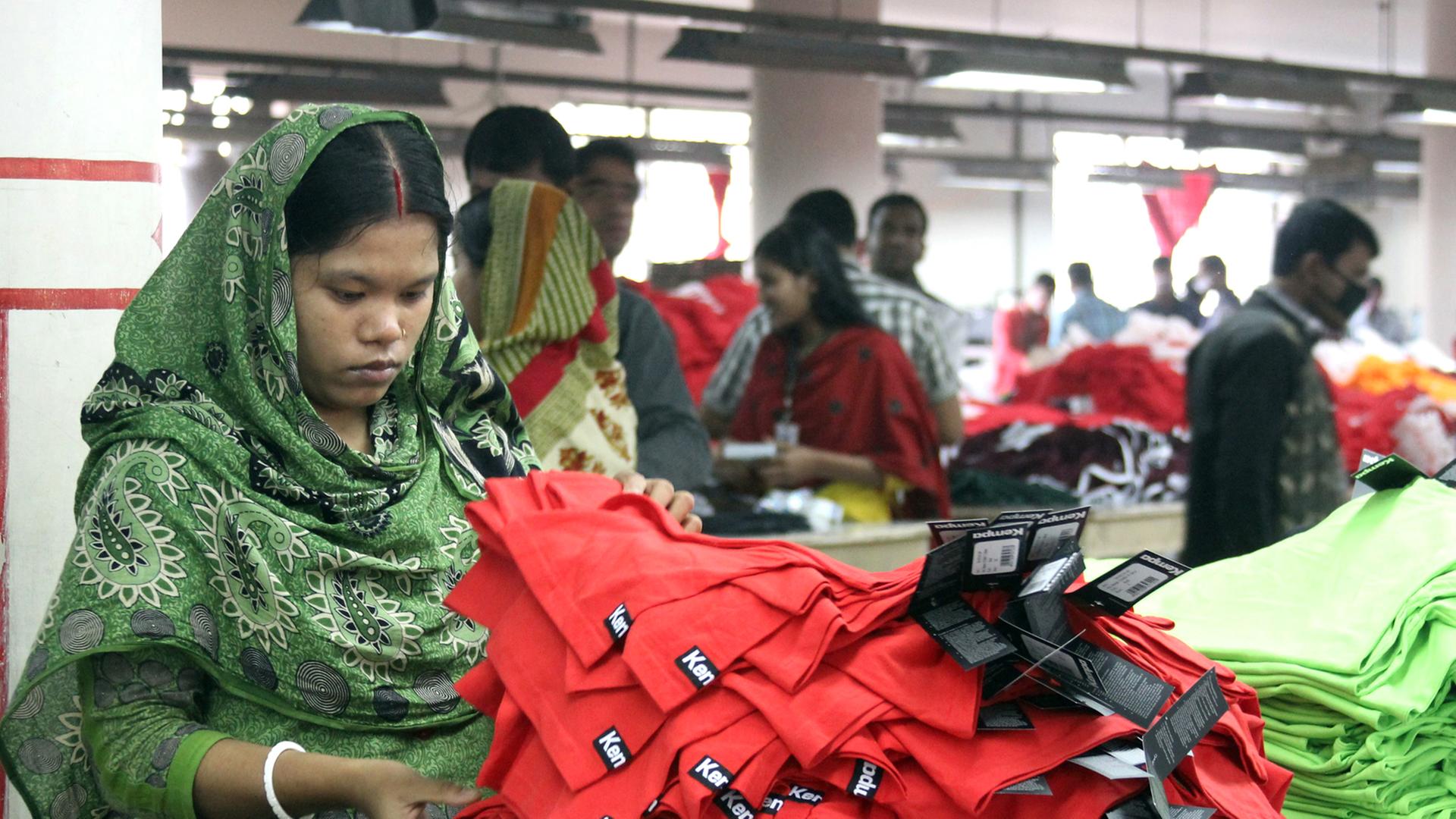 Frauen und Männer arbeiten am 03.01.2014 in der Textilfabrik "One Composite Mills" in Gazipur, einem Vorort der Hauptstadt Dhaka in Bangladesch. Frauen und Männer arbeiten am 03.01.2014 in der Textilfabrik "One Composite Mills" in Gazipur, einem Vorort der Hauptstadt Dhaka in Bangladesch.