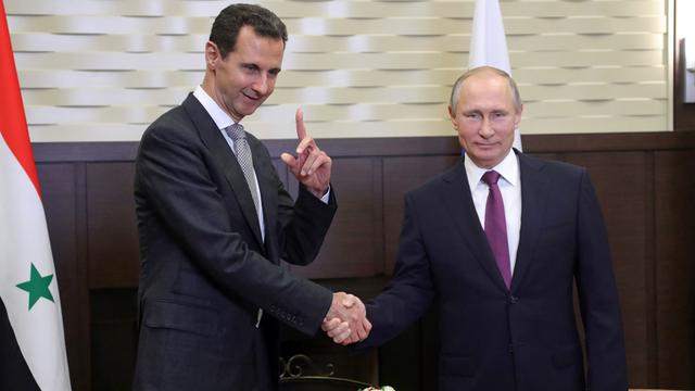 Syriens Präsident Bashar al-Assad und Russlands Präsident Vladimir Putin beim Handschlag, im November 2017 in Russland