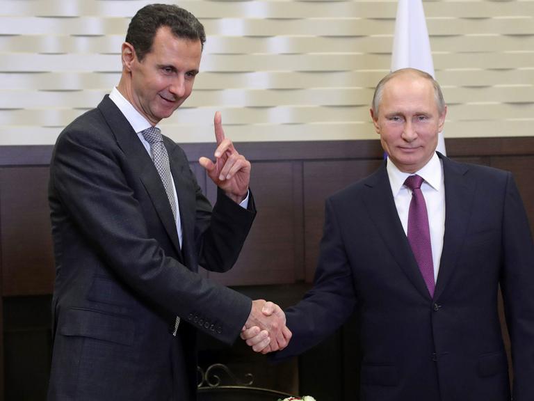 Syriens Präsident Bashar al-Assad und Russlands Präsident Vladimir Putin beim Handschlag, im November 2017 in Russland