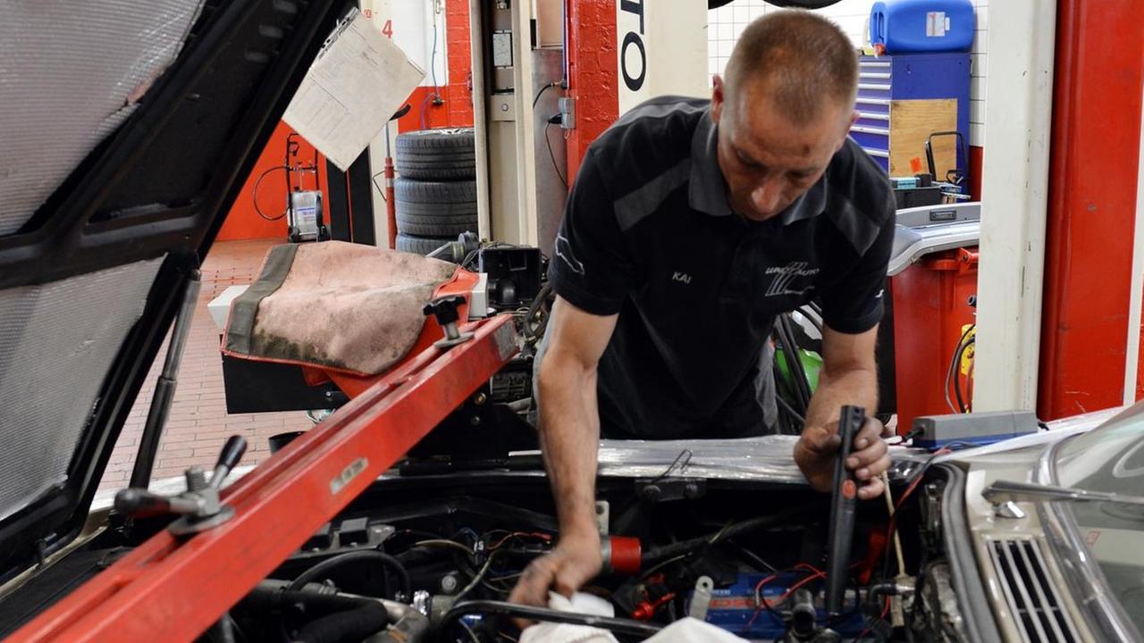 Ein KFZ-Mechaniker arbeitet am 23.05.2016 in einer KFZ-Werkstatt in Berlin an der Reparatur eines Autos.