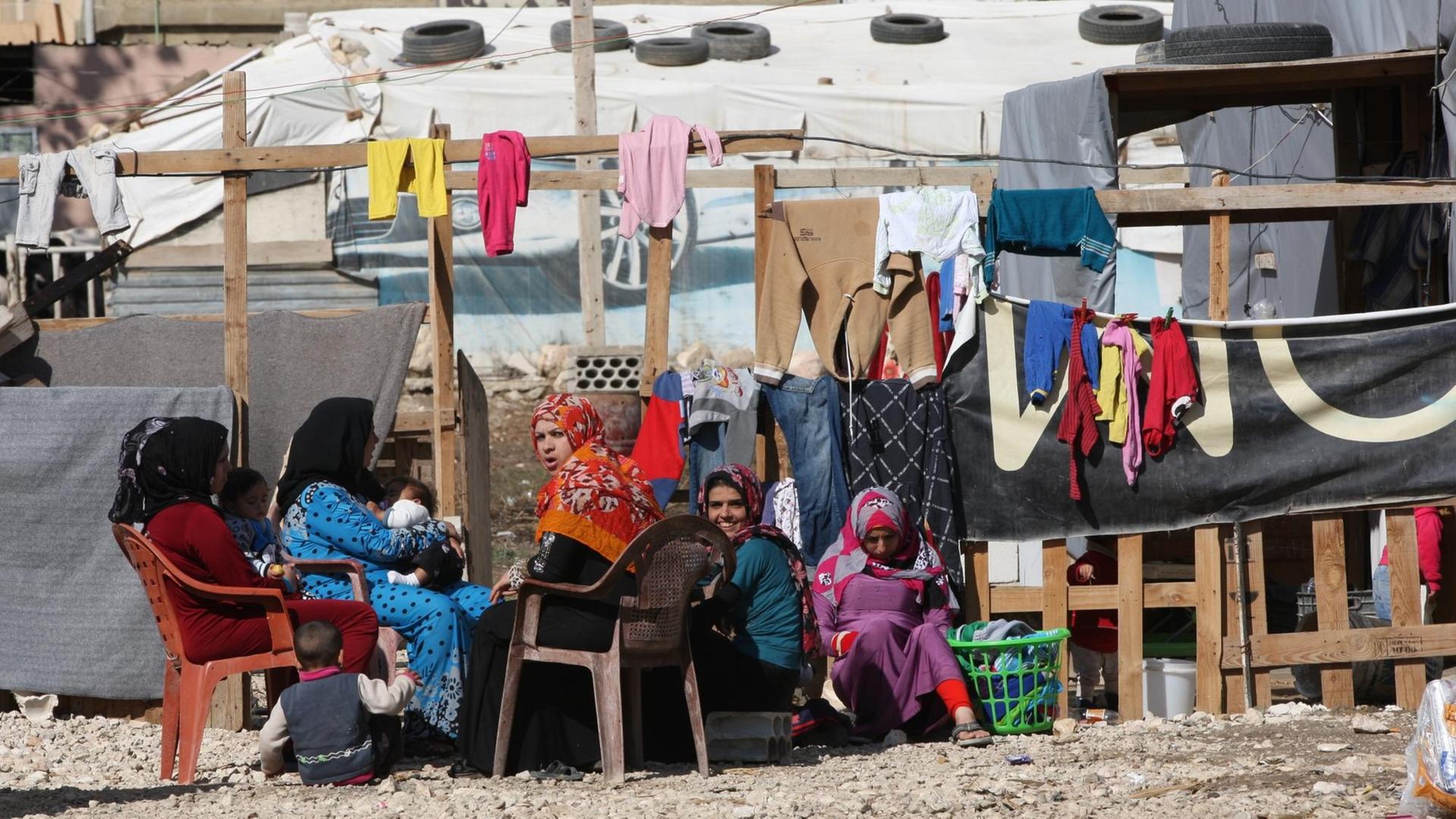 Frauen sitzen am 10.11.2015 im Libanon in der Bekaa Ebene in einem Flüchtlingslager vor ihren Behausungen. Die zumeist syrischen Flüchtlinge aus der Region Frauen sitzen am 10.11.2015 im Libanon in der Bekaa Ebene in einem Flüchtlingslager vor ihren Behausungen. Die zumeist syrischen Flüchtlinge aus der Region