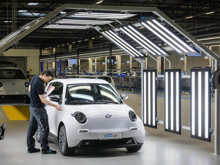Ein Mitarbeiter bei der Endkontrolle eines e.GO Life Elektroautos in der Montagehalle in Aachen