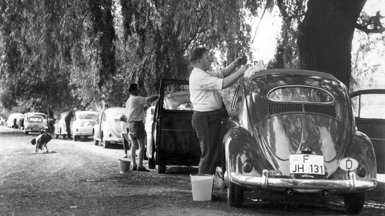 Am Samstag fährt der ordentliche Mann zur Autowäsche mit seinem Wagen an das nächstgelegene Gewässer, wie hier im Jahr 1960. Nicht jeder Autobesitzer ist gewillt oder in der Lage, Geld für eine Reinigung des "liebsten Kindes" zu bezahlen. Foto: Willi Gutberlet +++(c) dpa - Report+++ Am Samstag fährt der ordentliche Mann zur Autowäsche mit seinem Wagen an das nächstgelegene Gewässer, wie hier im Jahr 1960. Nicht jeder Autobesitzer ist gewillt oder in der Lage, Geld für eine Reinigung des "liebsten Kindes" zu bezahlen. Foto: Willi Gutberlet +++(c) dpa - Report+++