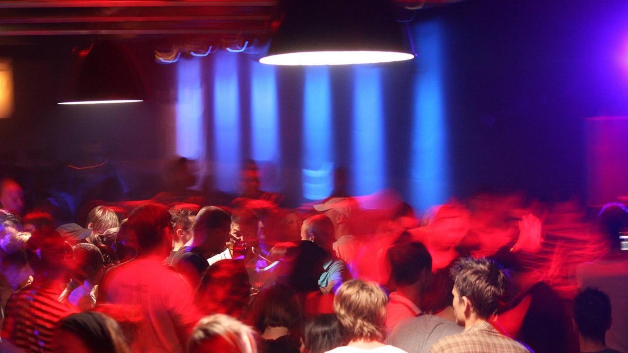 Aufnahme von 2007 aus dem Club "Tresor" in Berlin. Menschen tanzen in rotes und blaues Licht getaucht.