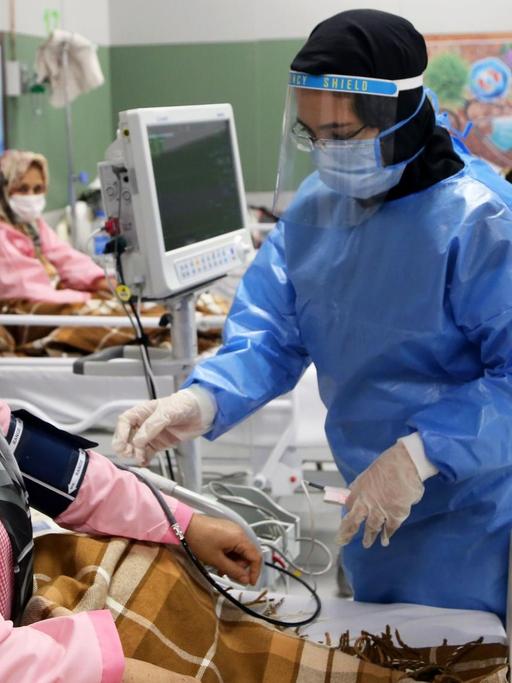 Im grössten Einkausfszentrum in Teheran, der "Iranmall", ist ein Krankenhaus für Coronapatienten entstanden. Hier wird eine Patientin von einer Krankenpflegerin versorgt. Beide tragen Kopftuch und Mundschutz. Teheran, 30. März 2020, Iran.