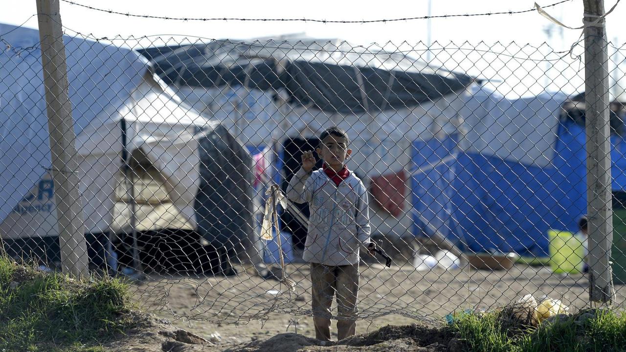 Ein Kind lehnt in einem Flüchtlingslager in der Nähe der Region Erbil an einem Zaun.