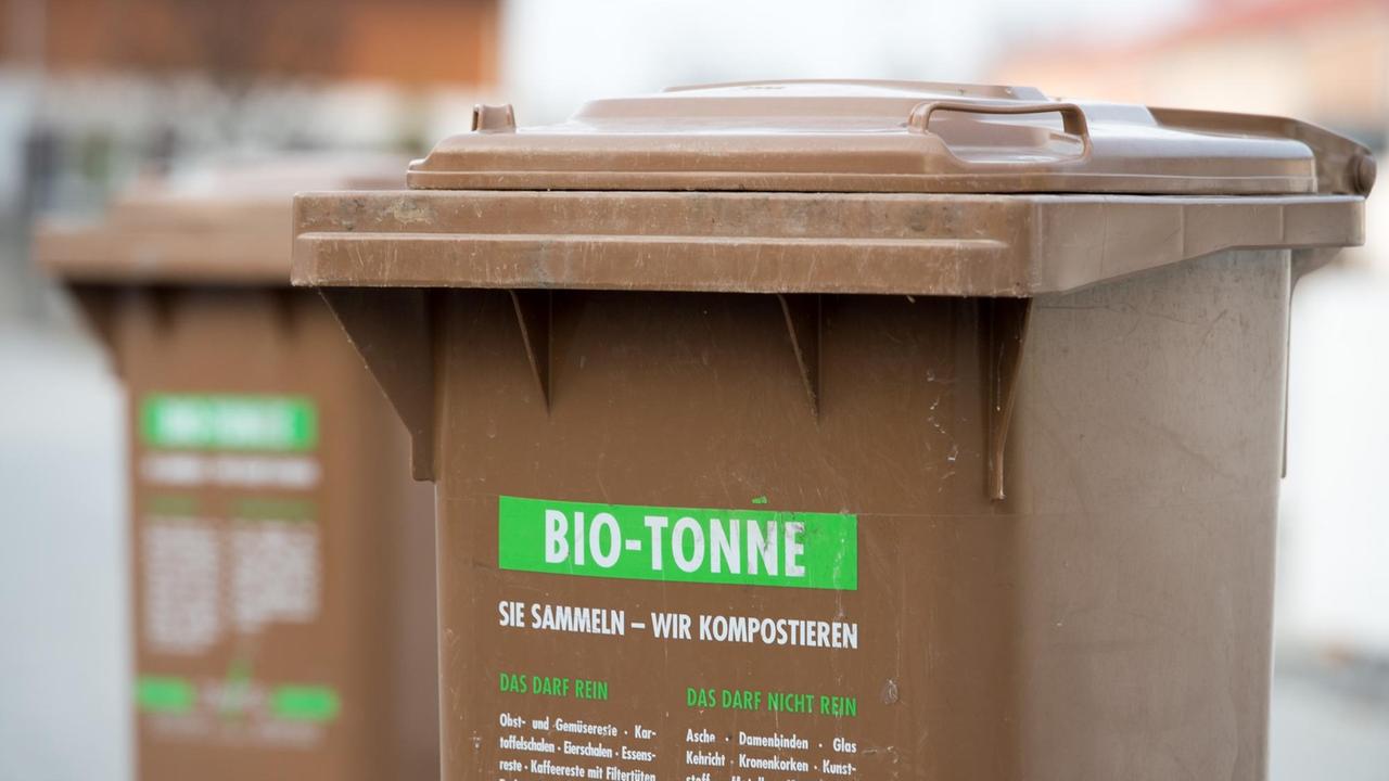 Eine braune Tonne mit der Aufschrift "Bio-Tonne - Sie sammeln, wir kompostieren". Eine braune Tonne mit der Aufschrift "Bio-Tonne - Sie sammeln, wir kompostieren".