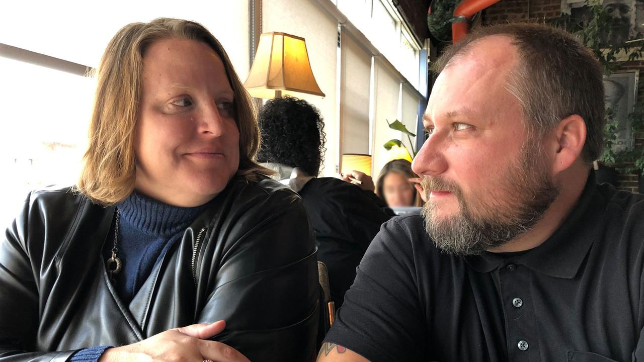 Carmen mit Ehemann TM. Eine Frau und ein Mann sitzen in einem Restaurant und schauen sich an.
