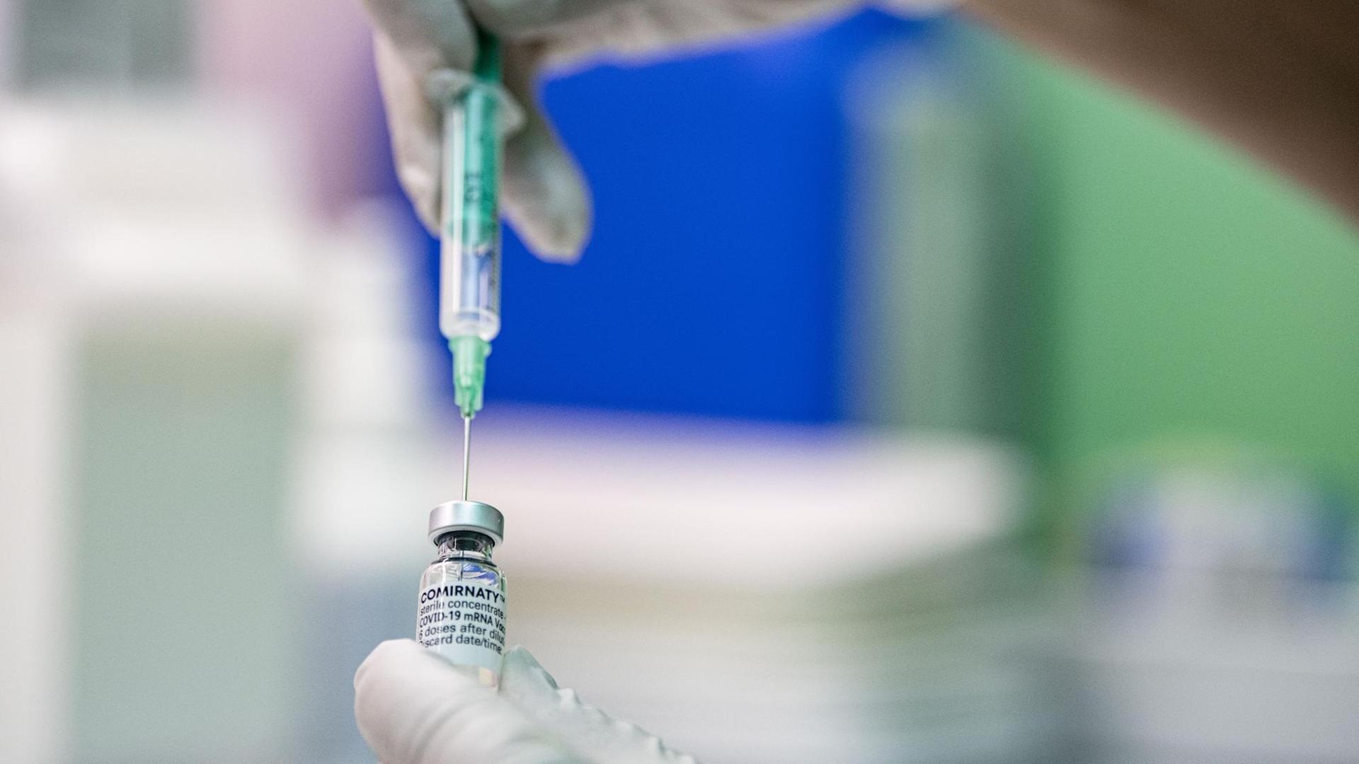 Ein Kinder- und Jugendarzt zieht den Corona-Impfstoff Comirnaty von Biontech/Pfizer in eine Spritze. Ein Kinder- und Jugendarzt zieht den Corona-Impfstoff Comirnaty von Biontech/Pfizer in eine Spritze.