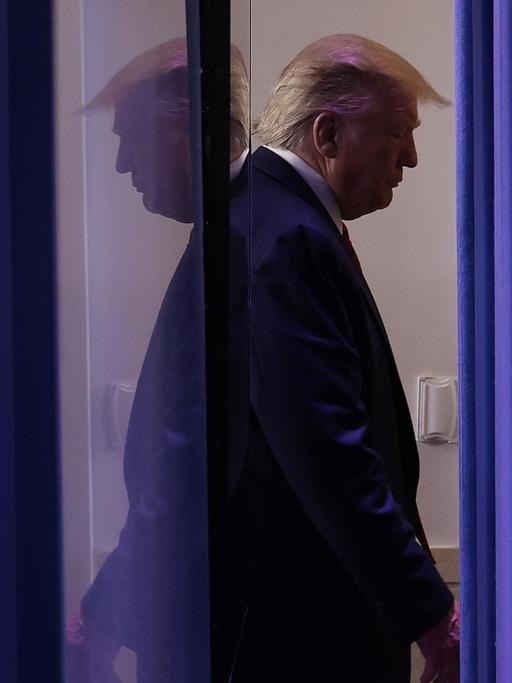US-Präsident Donald Trump verlässt den Brady Press Briefing Room, nachdem er und Mitglieder der Coronavirus Task Force des Weißen Hauses am 19. März 2020 im Weißen Haus in Washington, DC, eine Pressekonferenz abgehalten haben. Er spiegelt sich dabein in einer Schreibe doppelt.
