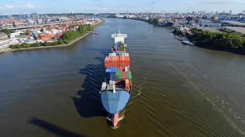 Ein Containerfrachter fährt im Hamburger Hafen über die Elbe.