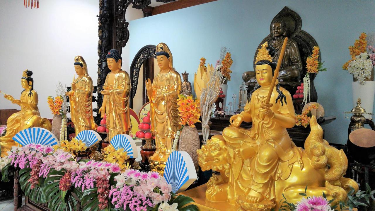 Eine Gruppe goldfarbiger Bodhisattva-Figuren, in ihrer Mitte der Buddha Amitabha