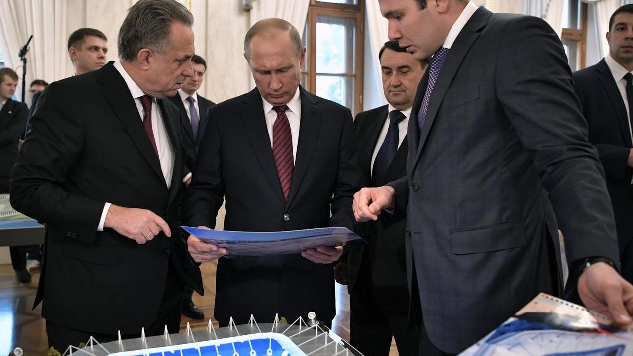 Russian President Vladimir Putin (2nd L), accompanied by deputy prime minister Vitaly Mutko (L), visits an exhibition devoted to the preparation for the 2018 FIFA World Cup at the Kremlin in Moscow on October 3, 2017. / AFP PHOTO / SPUTNIK / Alexey NIKOLSKY Russian President Vladimir Putin (2nd L), accompanied by deputy prime minister Vitaly Mutko (L), visits an exhibition devoted to the preparation for the 2018 FIFA World Cup at the Kremlin in Moscow on October 3, 2017. / AFP PHOTO / SPUTNIK / Alexey NIKOLSKY