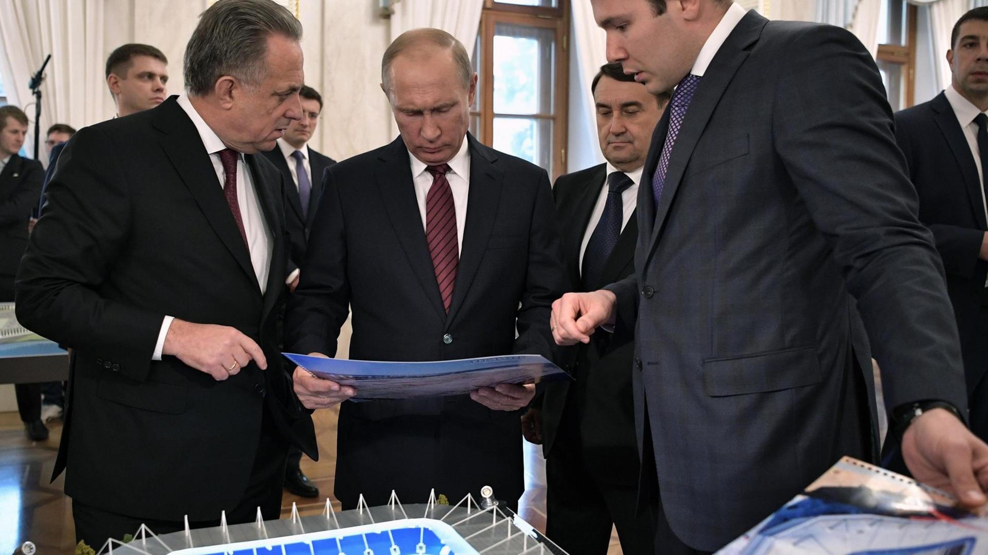 Russian President Vladimir Putin (2nd L), accompanied by deputy prime minister Vitaly Mutko (L), visits an exhibition devoted to the preparation for the 2018 FIFA World Cup at the Kremlin in Moscow on October 3, 2017. / AFP PHOTO / SPUTNIK / Alexey NIKOLSKY Russian President Vladimir Putin (2nd L), accompanied by deputy prime minister Vitaly Mutko (L), visits an exhibition devoted to the preparation for the 2018 FIFA World Cup at the Kremlin in Moscow on October 3, 2017. / AFP PHOTO / SPUTNIK / Alexey NIKOLSKY