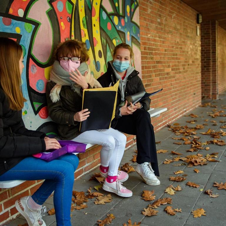 Kinder mit Maske auf dem Schulhof 