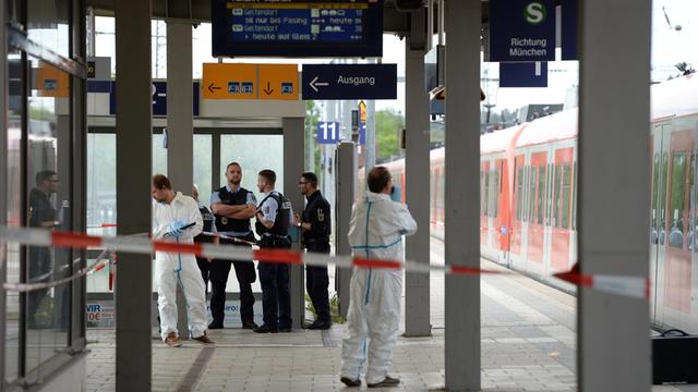 Polizisten stehen am 10.05.2016 am Bahnhof in Grafing bei München.