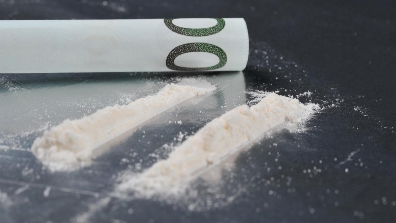 Zwei weiße Kokainlinien und ein Geldschein. Zwei weiße Kokainlinien und ein Geldschein.