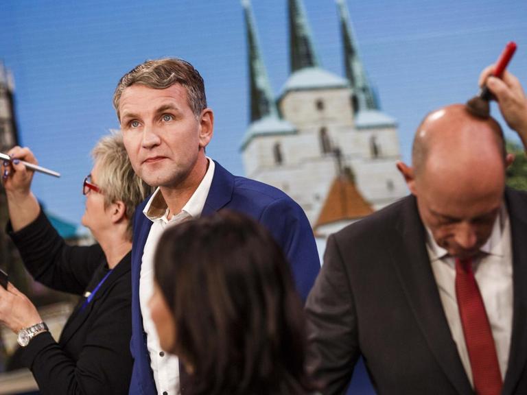  Björn Höcke von der rechten Alternative für Deutschland (AfD) kommt nach der Landtagswahl in Thüringen am 27. Oktober 2019 in Erfurt zu einem Fernsehinterview ins Studio, während weitere Gäste bereits von der Maske abgepinselt werden.