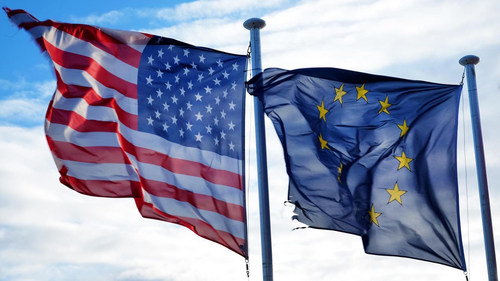 Die Fahnen der Vereinigten Staaten und der Europäischen Union wehen nebeneinander Die Fahnen der Vereinigten Staaten und der Europäischen Union wehen nebeneinander