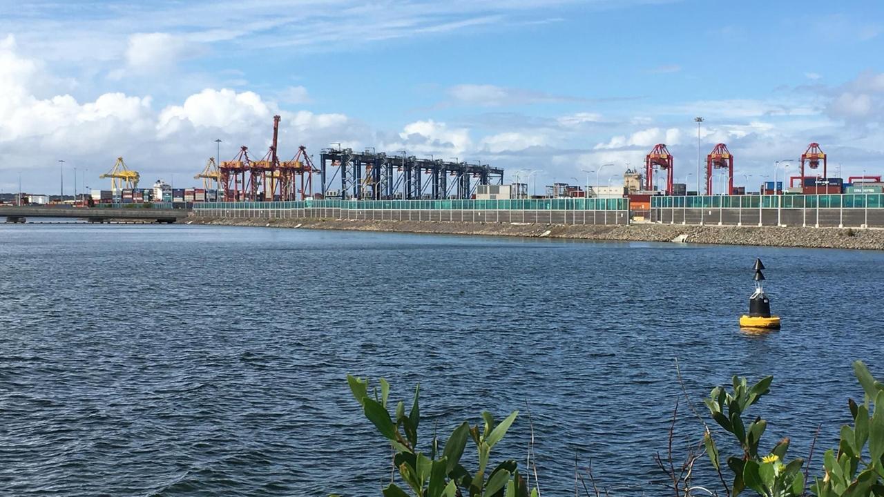 Blick auf den Containerhafen von Botany Bay. Im Vordergrund das Meer, im Hintergrund der Blick auf die Kräne des Hafens. Blick auf den Containerhafen von Botany Bay. Im Vordergrund das Meer, im Hintergrund der Blick auf die Kräne des Hafens.