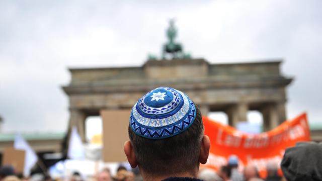 Teilnehmer der Kundgebung "Steh auf! Nie wieder Judenhass!" des Zentralrats der Juden in Deutschland stehen am 14.09.2014 vor dem Brandenburger Tor in Berlin.