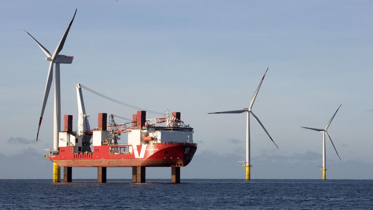 Windturbinen in einem Offshore-Windpark in der Nordsee mit Installations-Schiff. Windturbinen in einem Offshore-Windpark in der Nordsee mit Installations-Schiff.