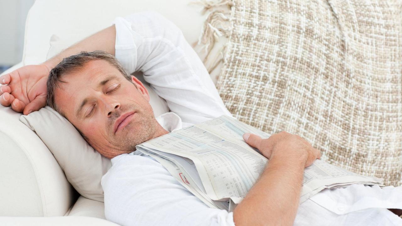 Exhausted man sleeping on the couch at home.