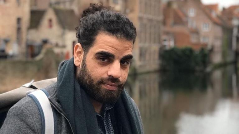Porträtfoto von Ahmad Katlesh vor dem Hintergrund deutscher Sandsteinhäuser an einem Fluss. Porträtfoto von Ahmad Katlesh vor dem Hintergrund deutscher Sandsteinhäuser an einem Fluss.