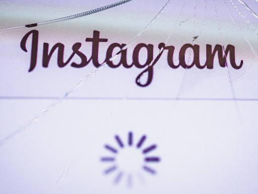 Das Instagram-Logo ist auf einem gesprungenen Display eines iPhones zu sehen