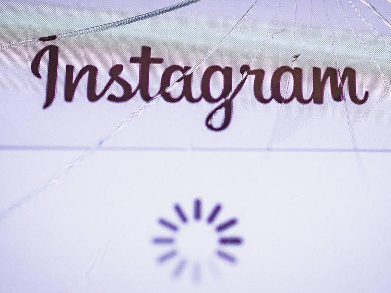 Das Instagram-Logo ist auf einem gesprungenen Display eines iPhones zu sehen