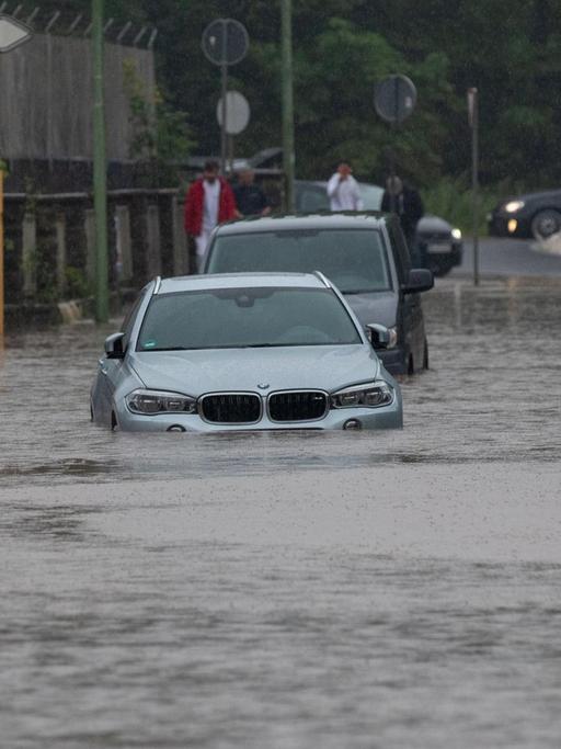 Mehrere Autos stecken nach Starkregen auf einer überfluteten Straße fest. Der Bach Vicht war über die Ufer getreten, das Gelände war überschwemmt.