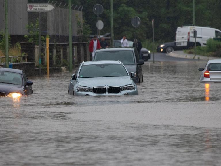 Mehrere Autos stecken nach Starkregen auf einer überfluteten Straße fest. Der Bach Vicht war über die Ufer getreten, das Gelände war überschwemmt.