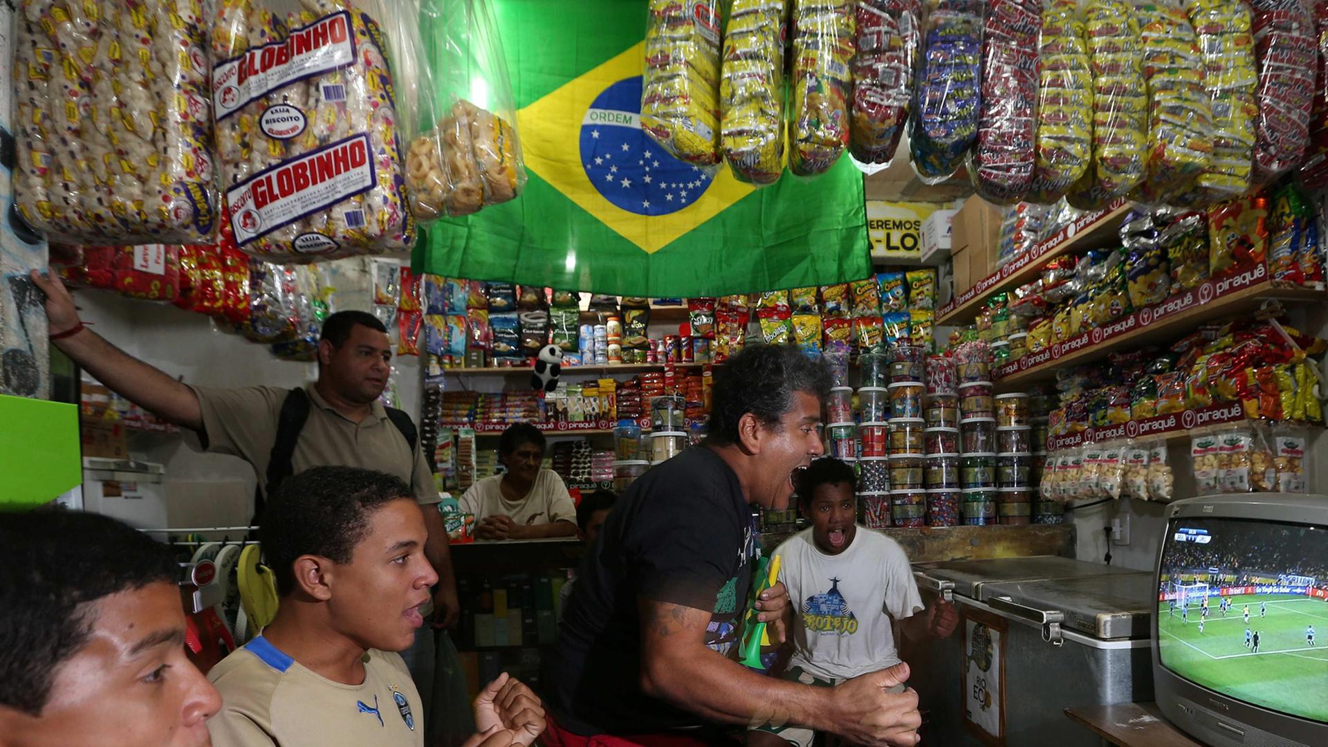 Brasilianer schauen ein Fußballspiel im Fernsehen an. Brasilianer schauen ein Fußballspiel im Fernsehen an.